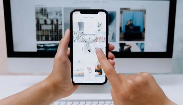 Dłonie przesuwające palcem siatkę zdjęć na smartfonie — karuzele na Instagramie