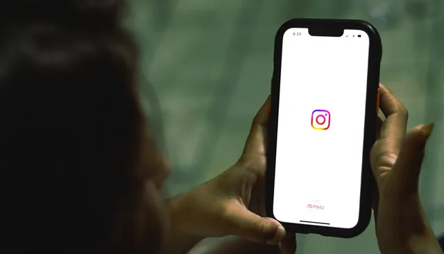 Dłonie trzymające telefon z otwartą aplikacją Instagram — konto profesjonalne na Instagramie
