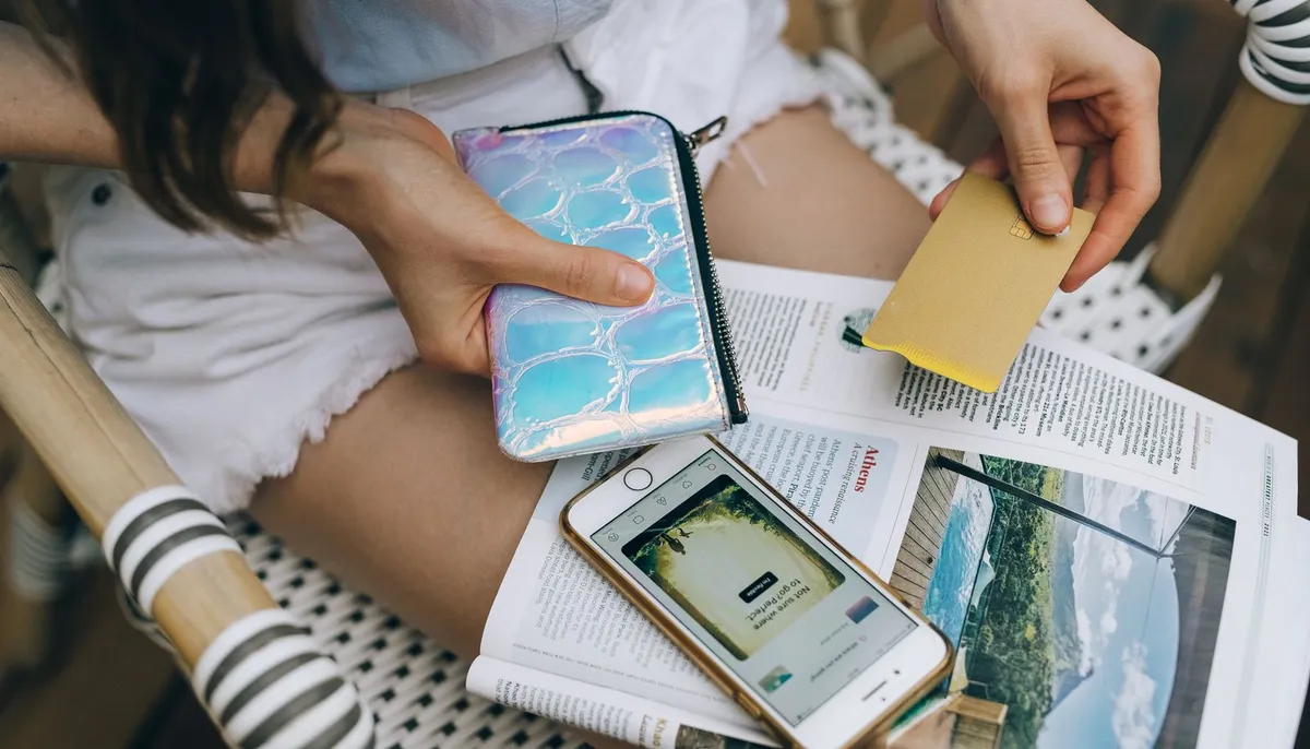 Kobieta z kartą płatniczą i telefonem — ile kosztuje reklama na Instagramie
