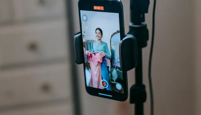 Smartfon na statywie nagrywający osobę do relacji na Instagramie — jak zwiększyć wyświetlenia relacji