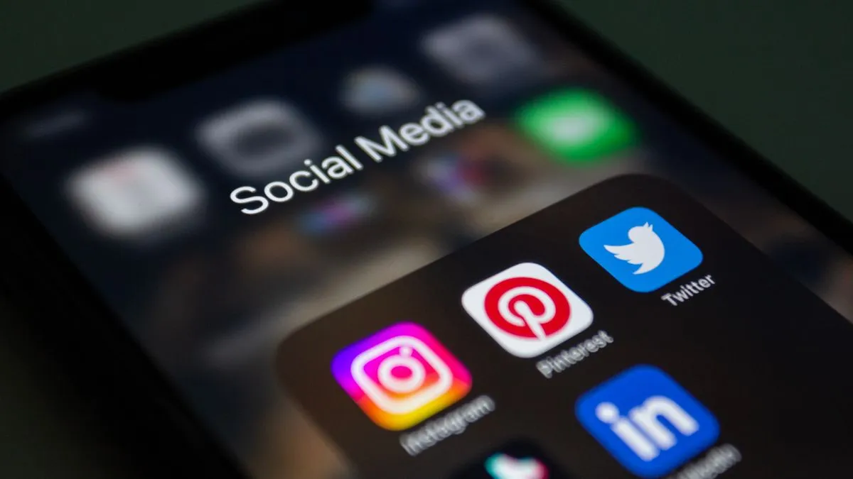 Ekran smartfona z folderem aplikacji social media (Instagram, Pinterest) — ilustracja zwiększania zasięgów na Instagramie
